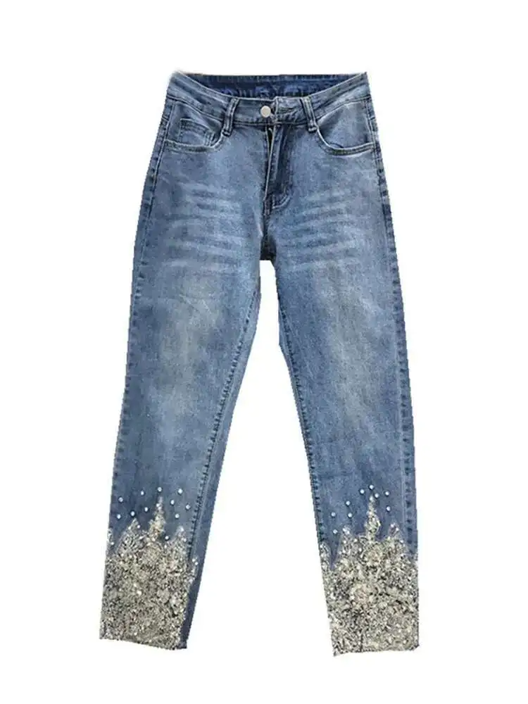 Blue jeans with glittery cuffs on a white background