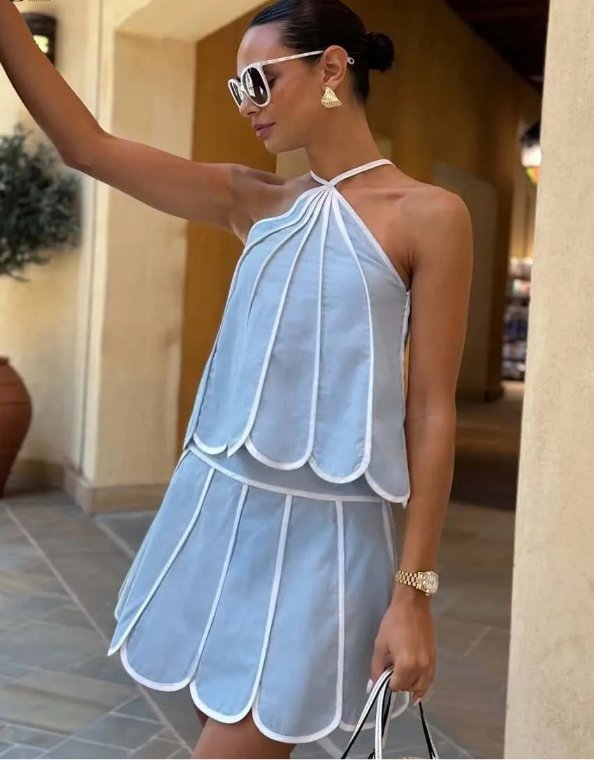 Woman wearing a light blue dress with white trim in an outdoor setting