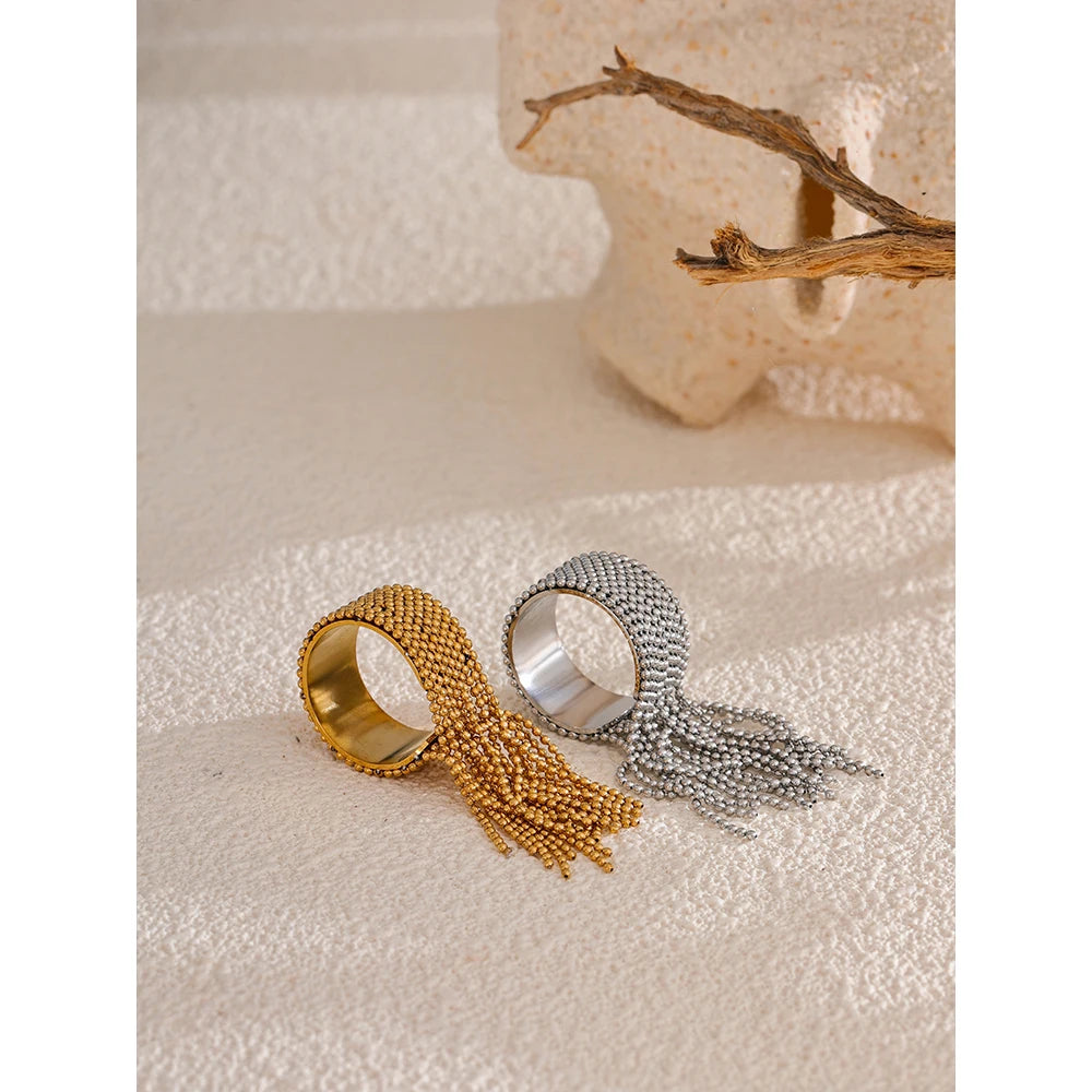 Gold and silver beaded rings on a textured surface with a neutral background