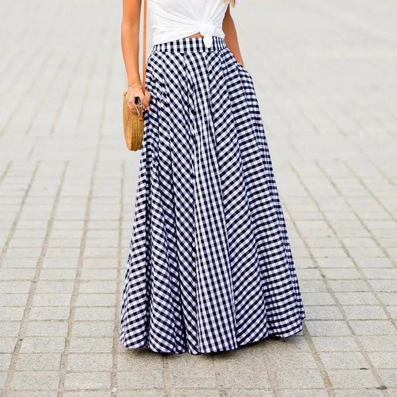 Person wearing a long black and white checkered skirt on a paved surface