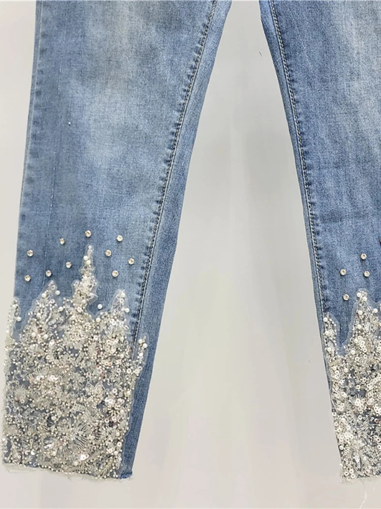 Blue jeans with glittery cuffs on a white background