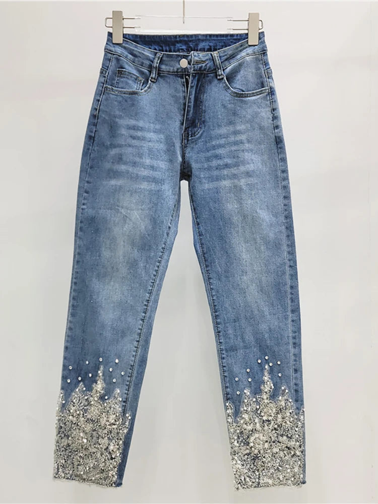 Blue jeans with glittery cuffs on a white background