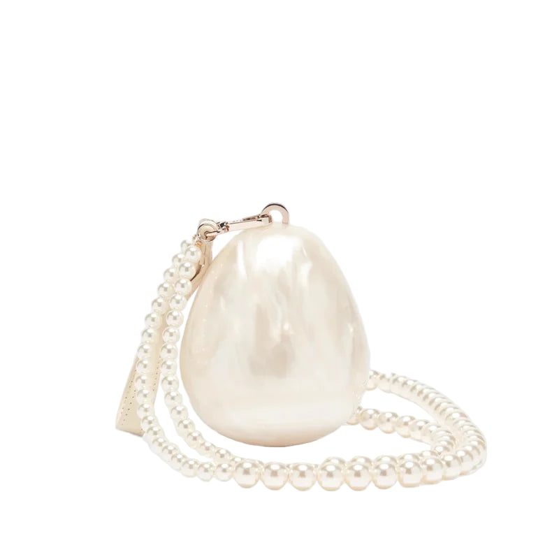 Pearl-handled handbag with chain strap on a white background.