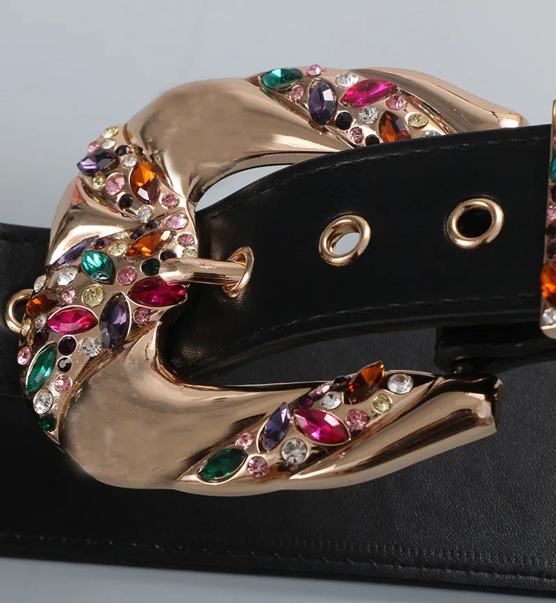 Belt buckle with colorful gemstones on a black belt against a gray background