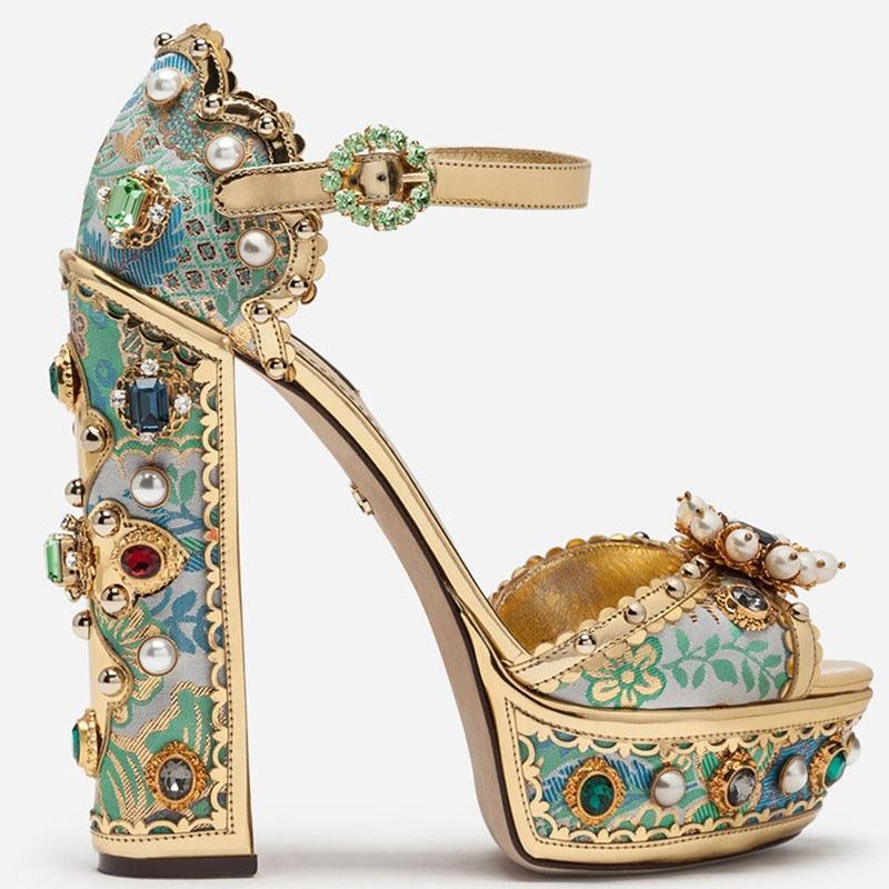 A high heel sandal with a floral pattern, embellished with rhinestones and faux pearls, featuring a square heel and a buckle strap.