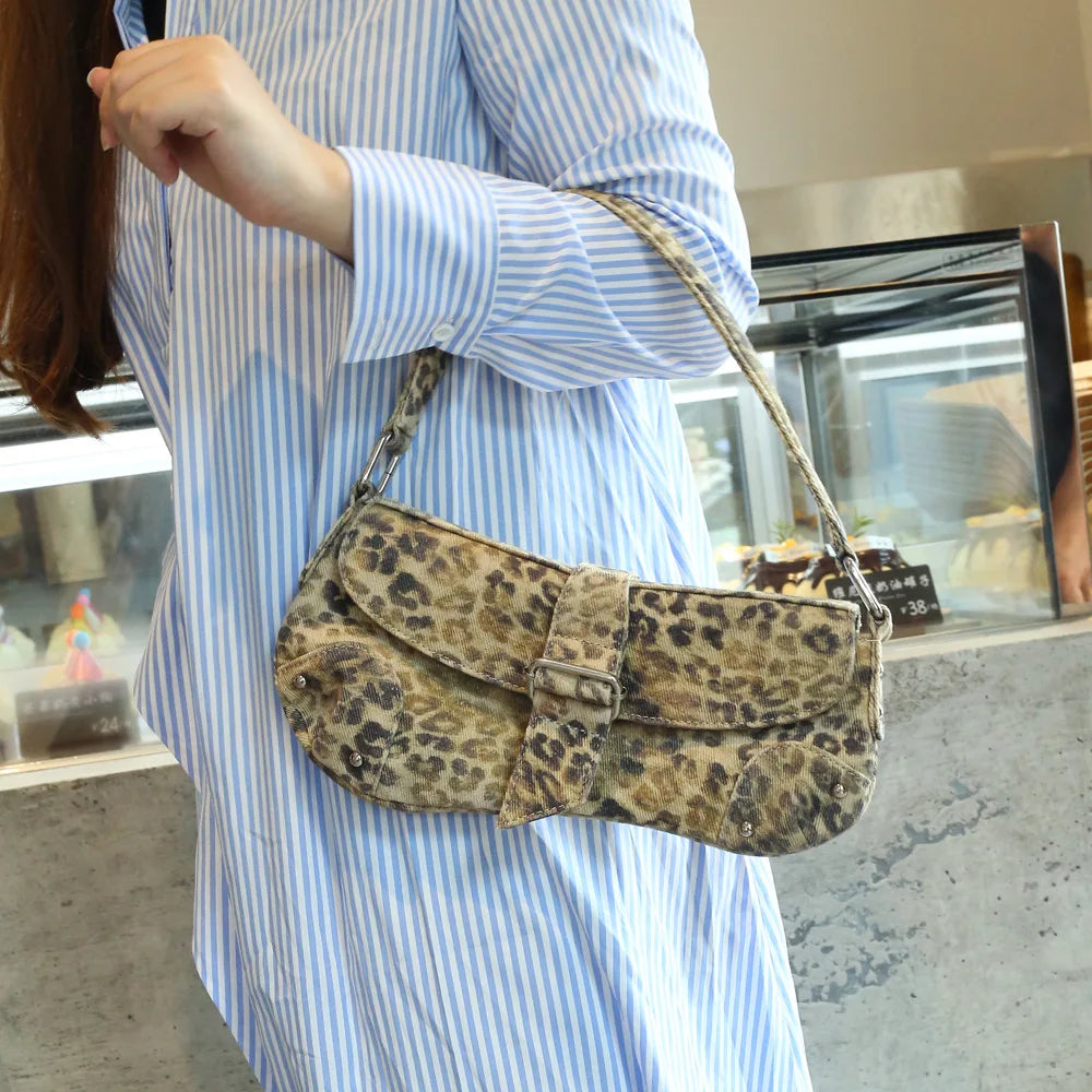Person wearing a blue striped shirt with a leopard print handbag.