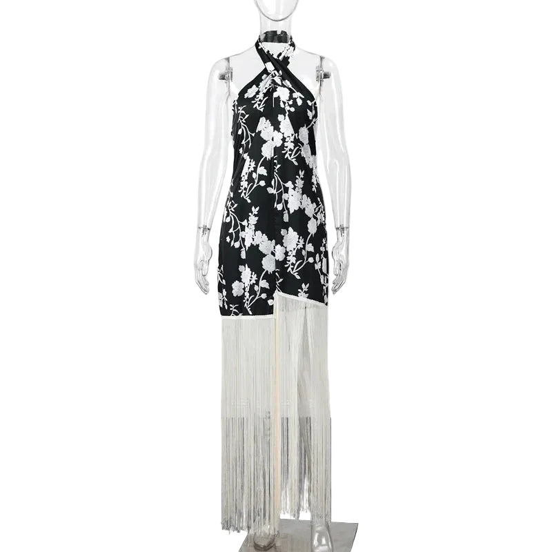 Mannequin wearing a black dress with white floral patterns and tassels.
