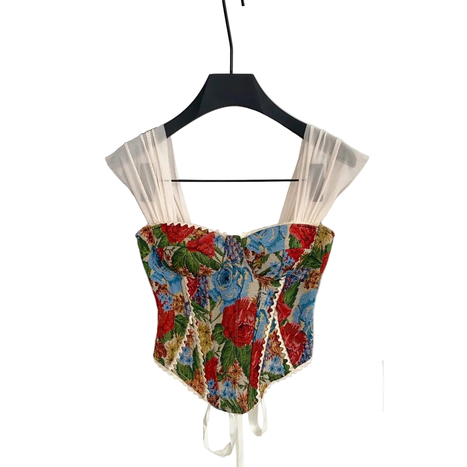 Floral corset top on a hanger against a neutral background