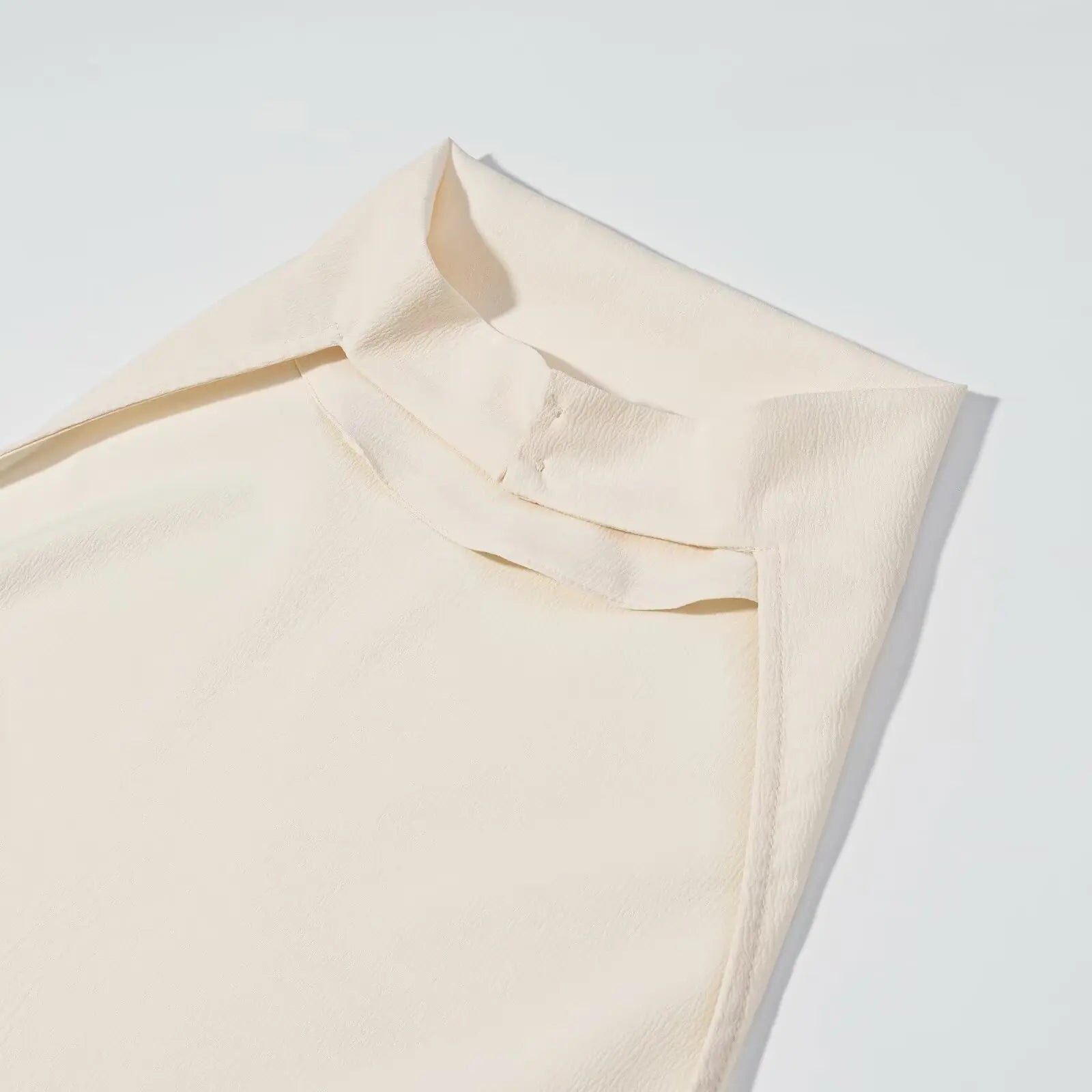 Beige fabric with a subtle texture on a light gray background