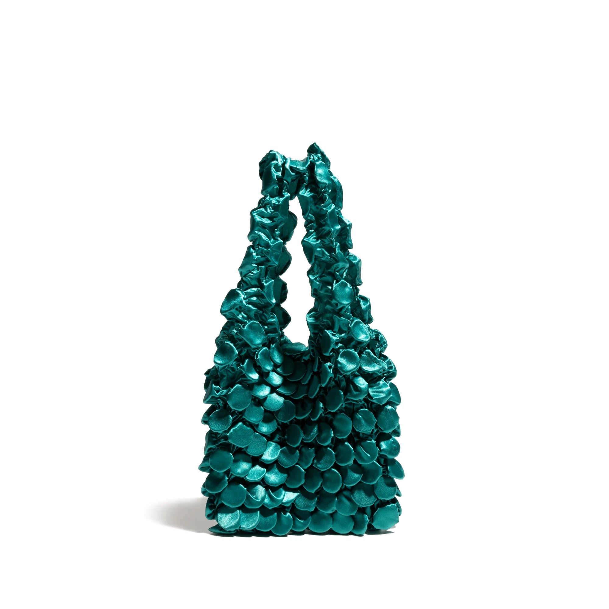 Turquoise handbag with textured surface on a white background