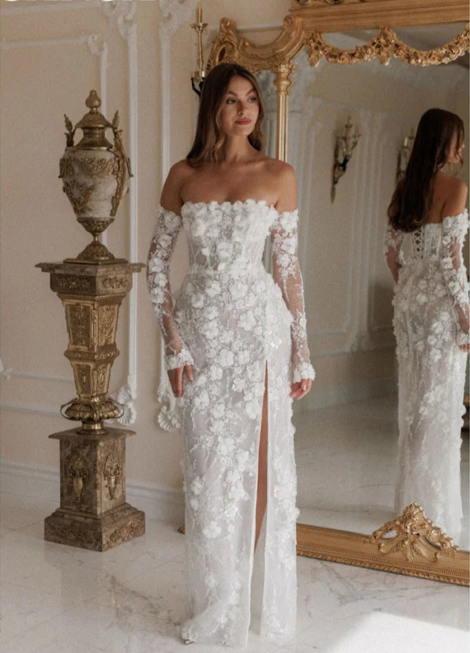 Woman in a white floral off-shoulder gown standing in a decorated room.