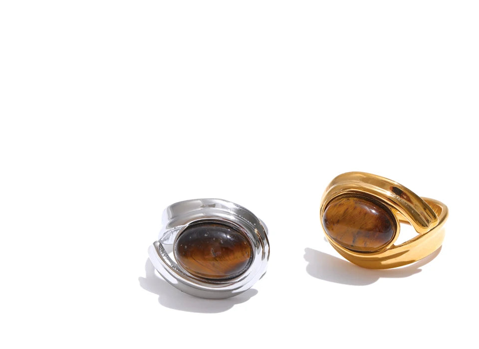 Two rings, one silver and one gold, with brown gemstones on a white background