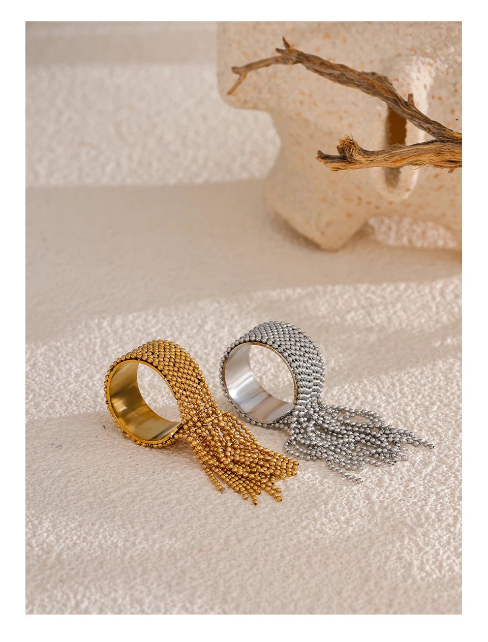 Gold and silver beaded rings on a textured surface with a blurred background
